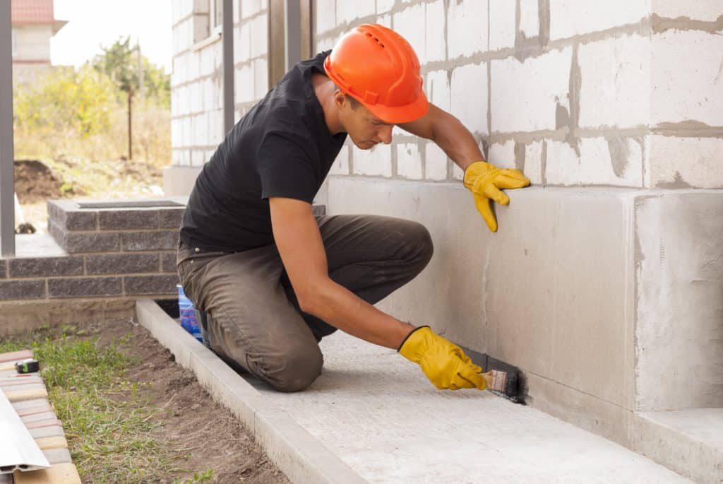 Murprotec: técnico aplicando tratamiento antihumedad en pared interior de vivienda